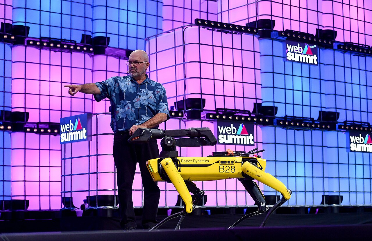 O engenheiro Marc Raibert, fundador da empresa norte-americana Boston Dynamics, com um dos robôs criados pela companhia, o Spot, que lembra um cachorro