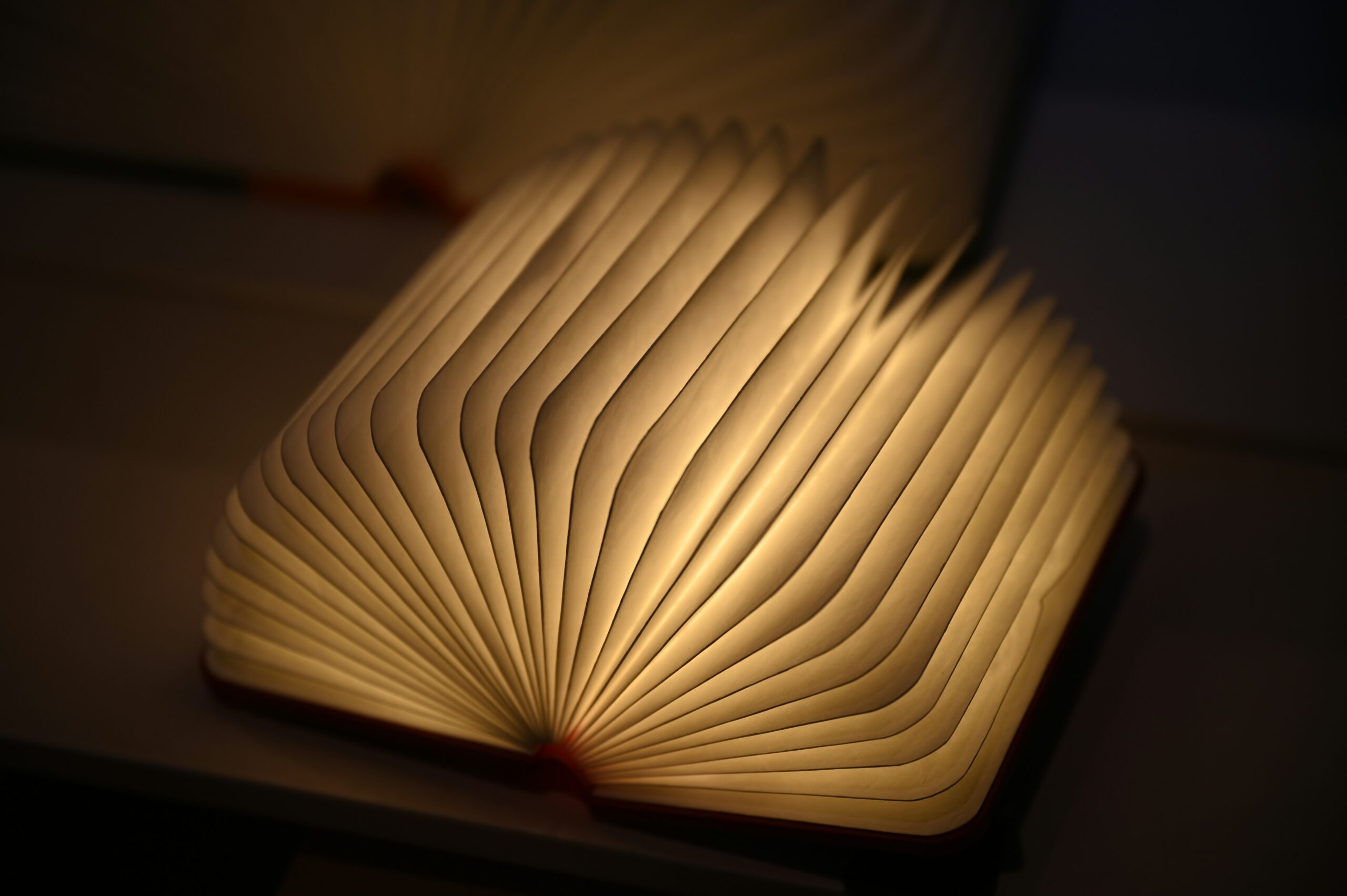 Image shows pages of a book emitting light, alluding to knowledge about driving innovation