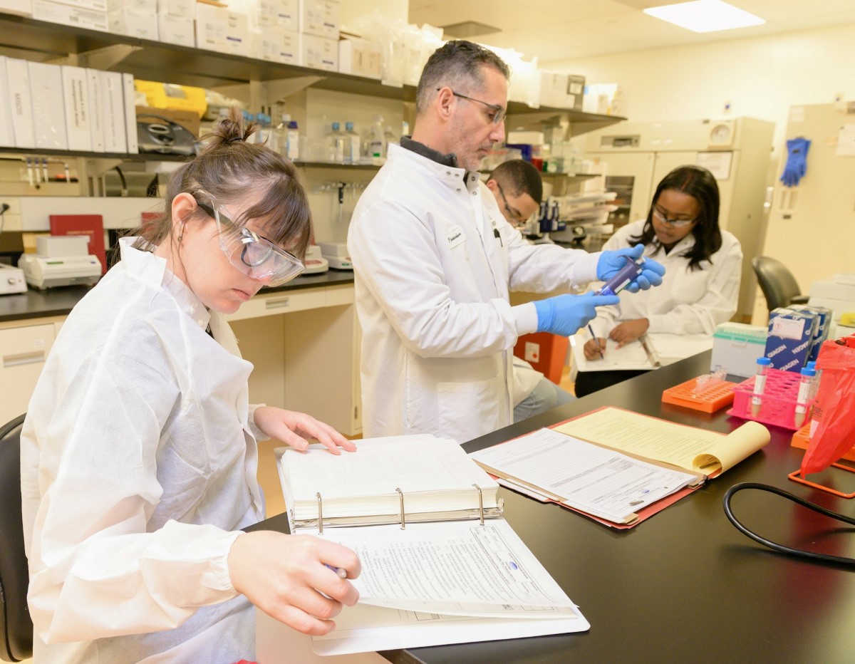 Healthcare professionals work in a laboratory, combining clinical practice with scientific research. The scene illustrates the daily routine of physician-scientists, including conducting experiments, maintaining records, and analyzing data.