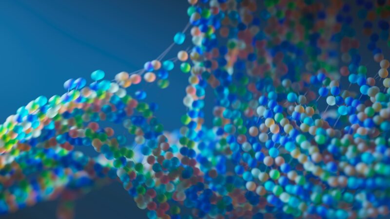 Ilustração digital em close-up de estruturas moleculares formadas por esferas coloridas (azul, verde, branco, rosa e dourado) conectadas por filamentos finos, organizadas em cadeias entrelaçadas sobre fundo azul desfocado, remetendo a sequências de aminoácidos.