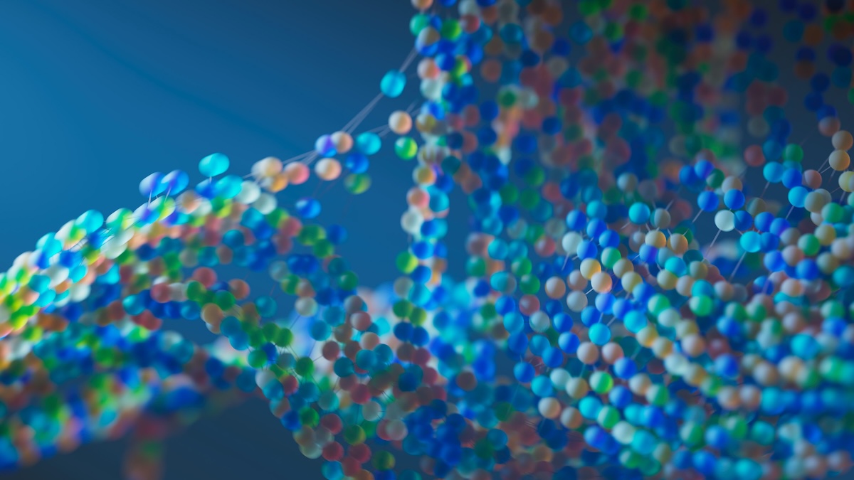 Close-up digital illustration of molecular structures composed of multicolored spheres (blue, green, white, pink, and gold) connected by fine strands, arranged as intertwined chains against a blurred blue background, evoking amino acid sequences.